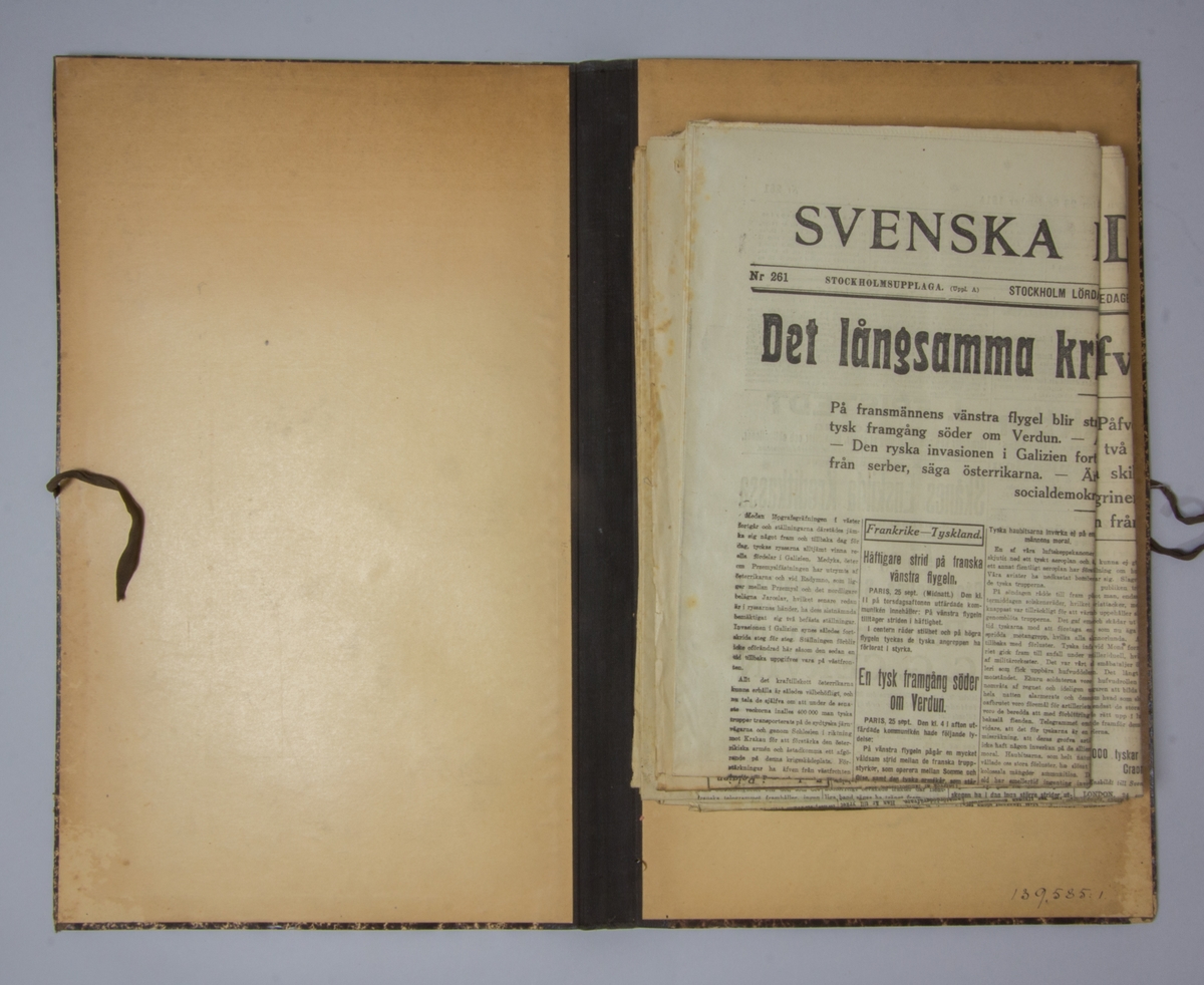 Portfölj av marmorerad papp. Sammanhållen med knytband. Rygg av svart linne. Innehåller enbart flera exemplar av Svenska Dagbladet från 1914.