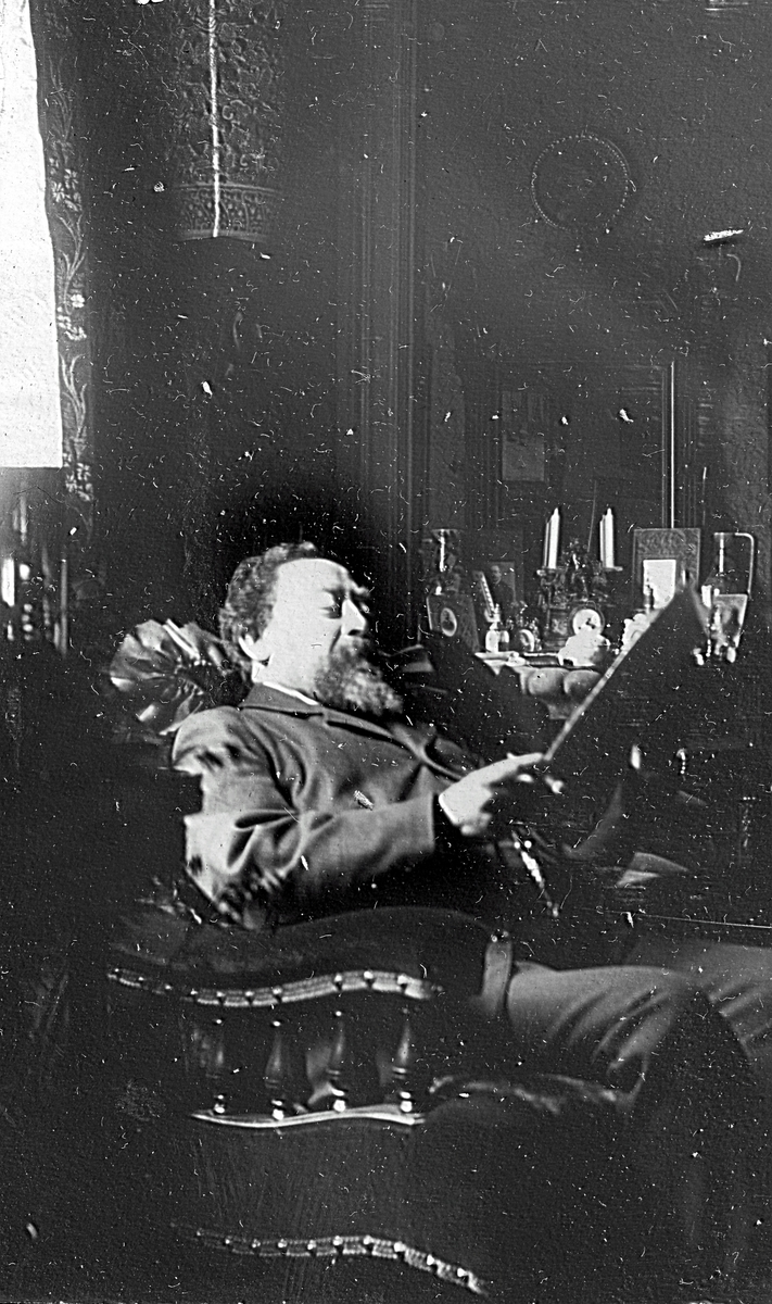 En man som sitter och läser. Fotograf Alfred Bergendahl. Givare H Bergendahl.