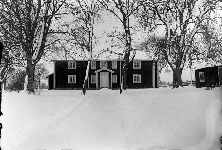 Foto av en mangårdsbyggnad i snö.