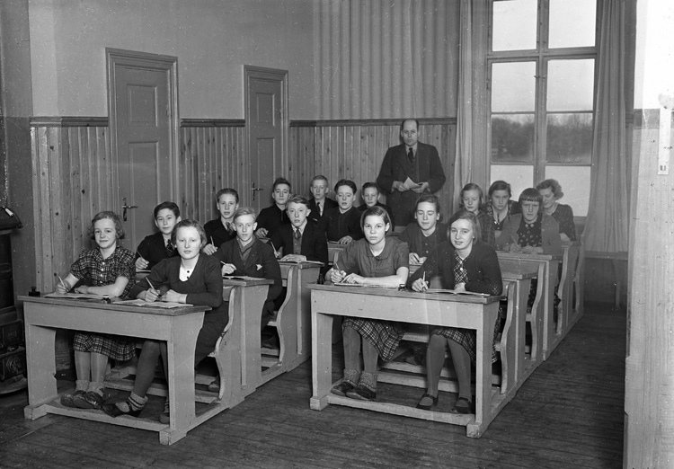 Foto av en skolklass med lärare i ett klassrum.