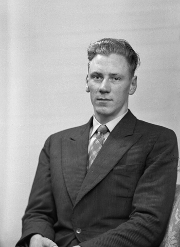 Foto av en man i kostym med slips.
Midjebild. Ateljéfoto.
Stig Frisk (senare Magnell), (1937-   ), Norra Vare Norregård, komministerboställe, Blädinge.
Jfr MINI1526.