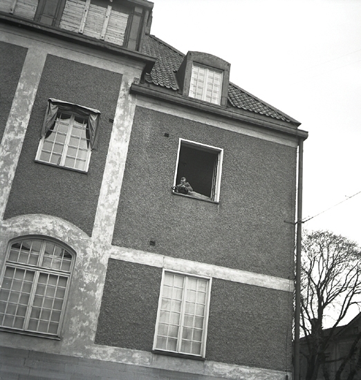 Hemvärnet, 1942. 
En man i hemvärnsuniform har fattat posto i ett öppet fönster
i dåv. Post- och Riksbankshuset.