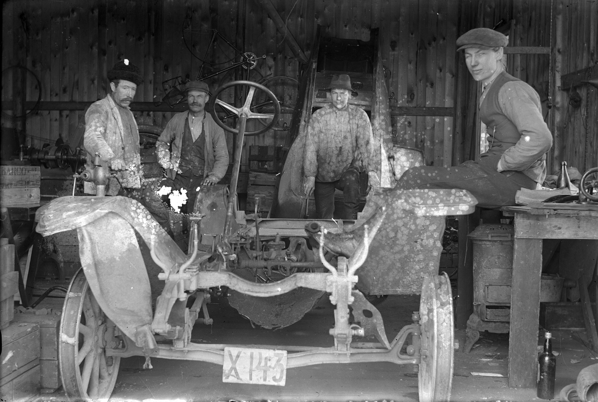 Fyra män och en bil. NAG 1912, ägare handlaren Albert Berglin, Torsåker. Källarmästare Blomqvist, Torsåker, sittande till höger.
Bilregistreringsnummer X143.