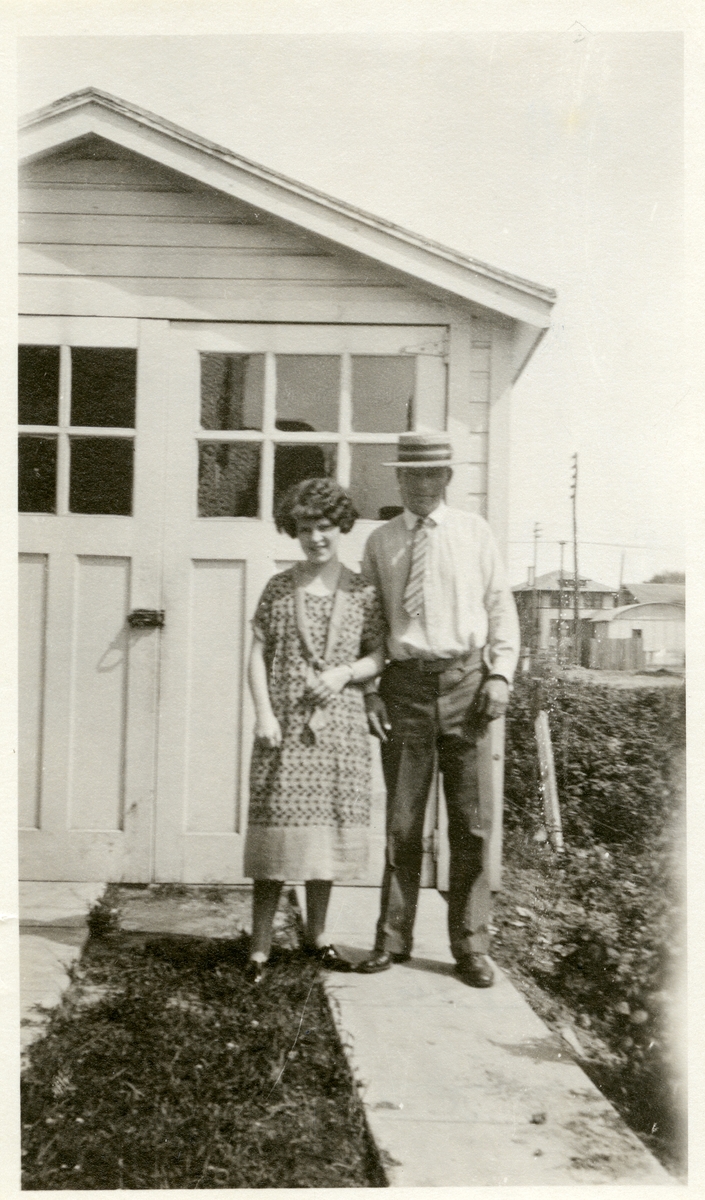 Mann og kvinne avbildet utenfor en garasje