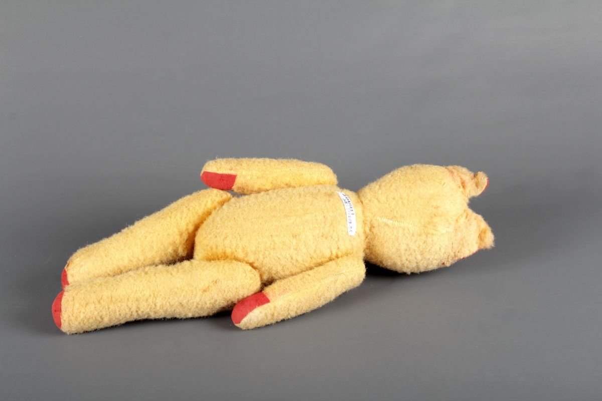 Gul bamse med halmfyll. ledda armar, bein og hovud