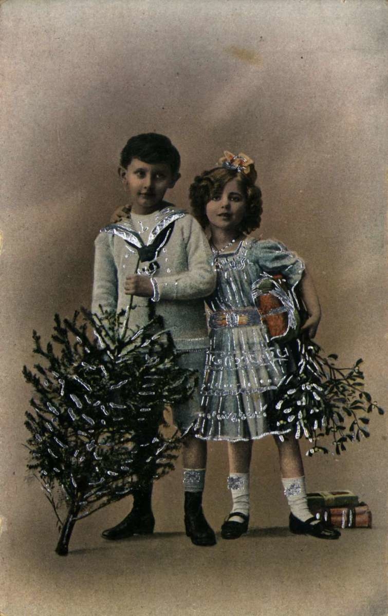 Julekort. Nyttårshilsen. Dekorert med sølvfarge. Gutt og pike pyntet til fest med juletre og pakker. Datert 21.12.1922.