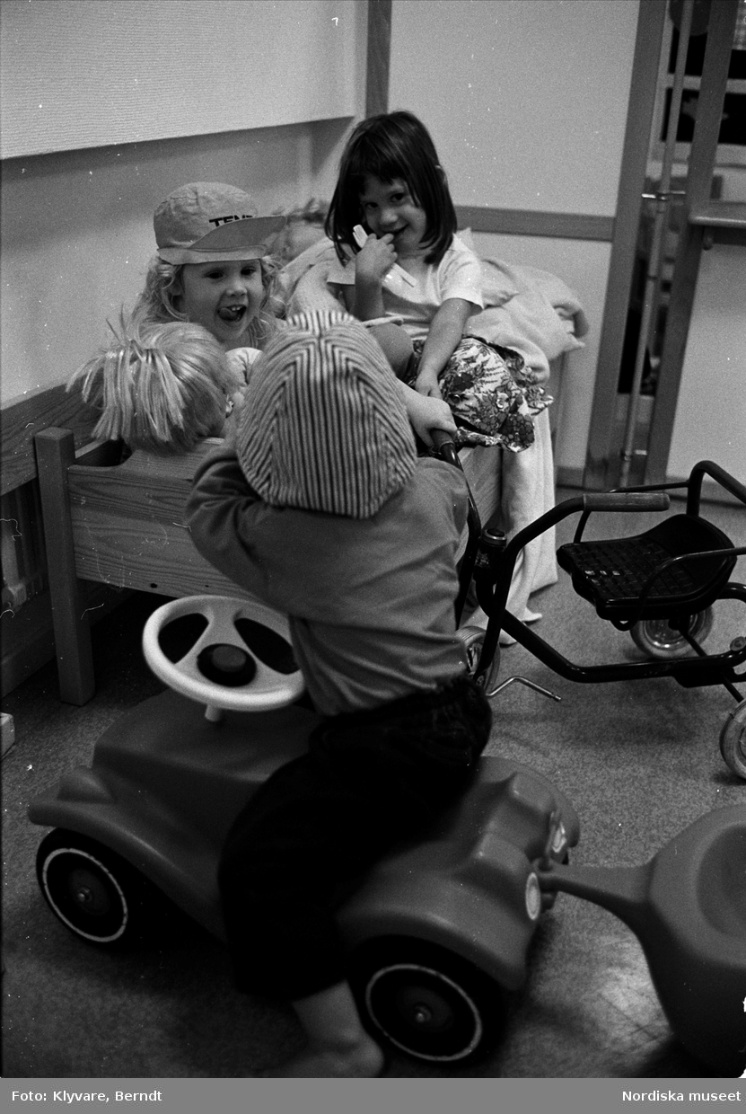 Barn med dockor och leksaksbil.