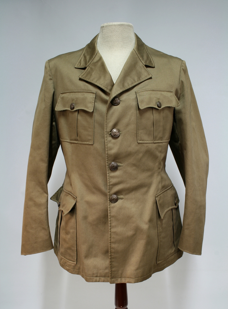 Nokså lik 1953 modellen. Enkeltkneppet brun jakke med fire knapper, fire ytterlommer og nedbrettet krage.