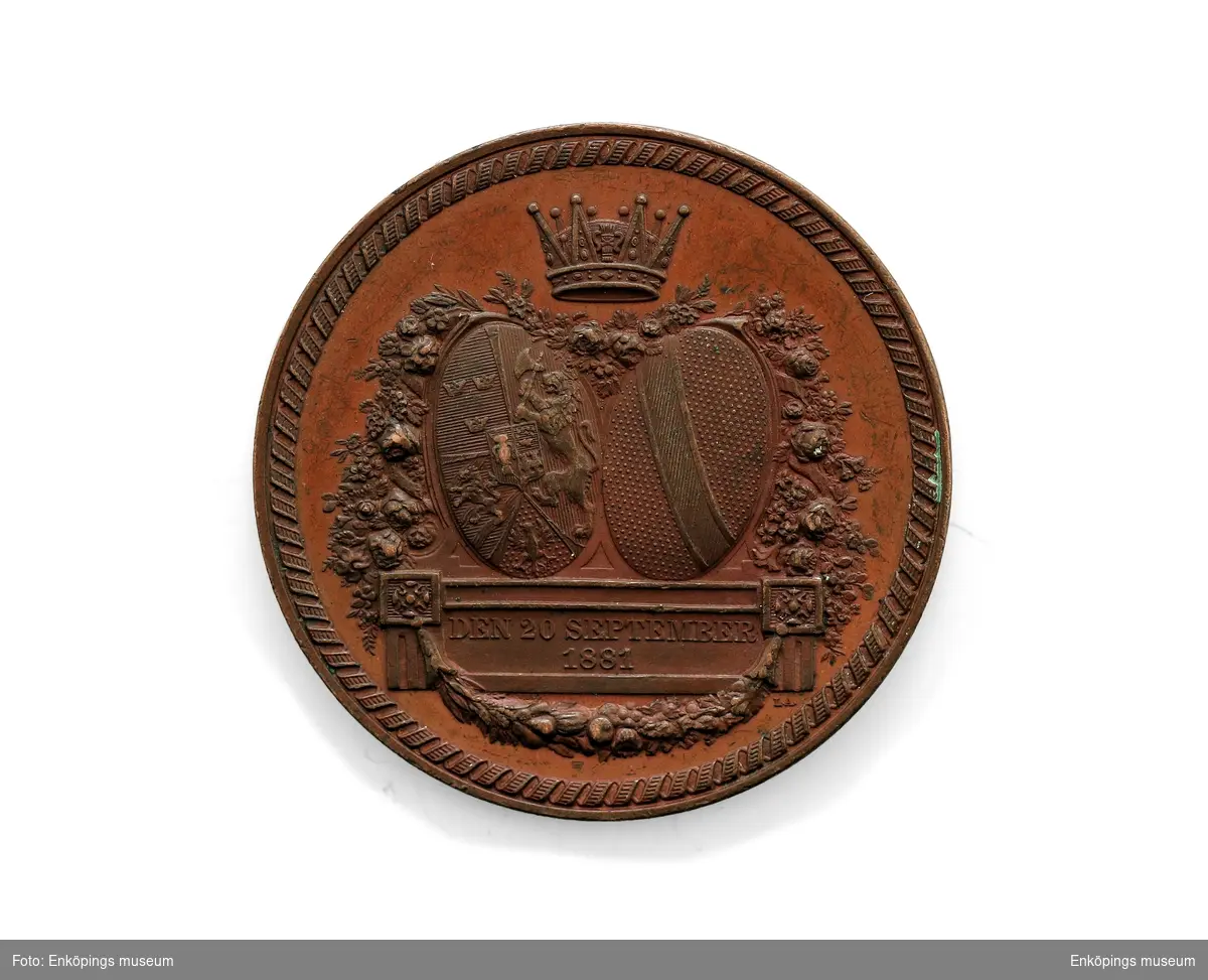 Rund medalj av koppar visande profilbild av man och kvinna med texten " GUSTAF" " VICTORIA". På baksidan två vapensköldar krönt med en krona, inklädda med blomstergirlanger. Texten " DEN 20 SEPTEMBER 1881".