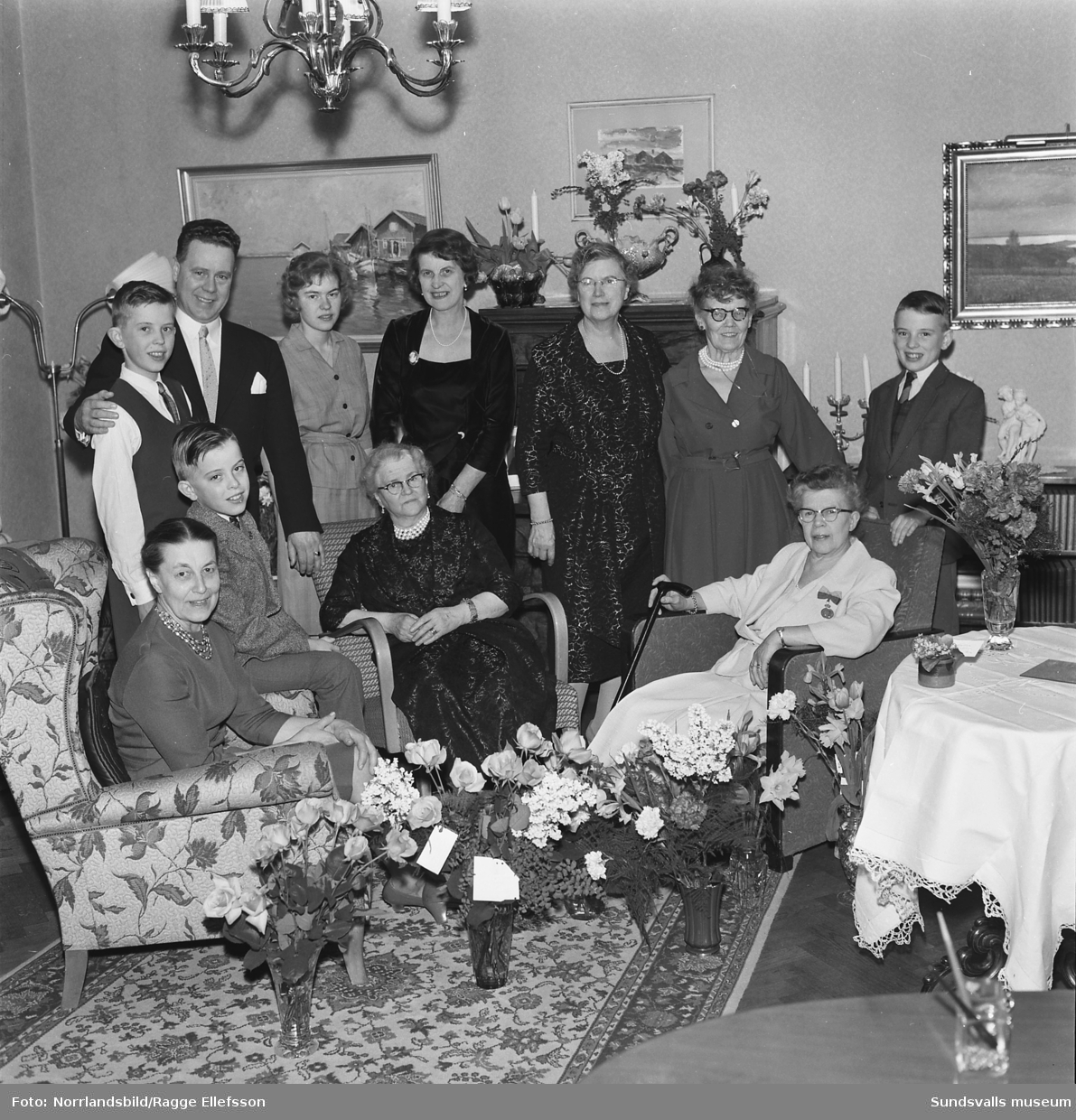 Födelsedagsporträtt av Emmy Lindholm på hennes 70-årsdag samt en gruppbild med familj och släkt.
