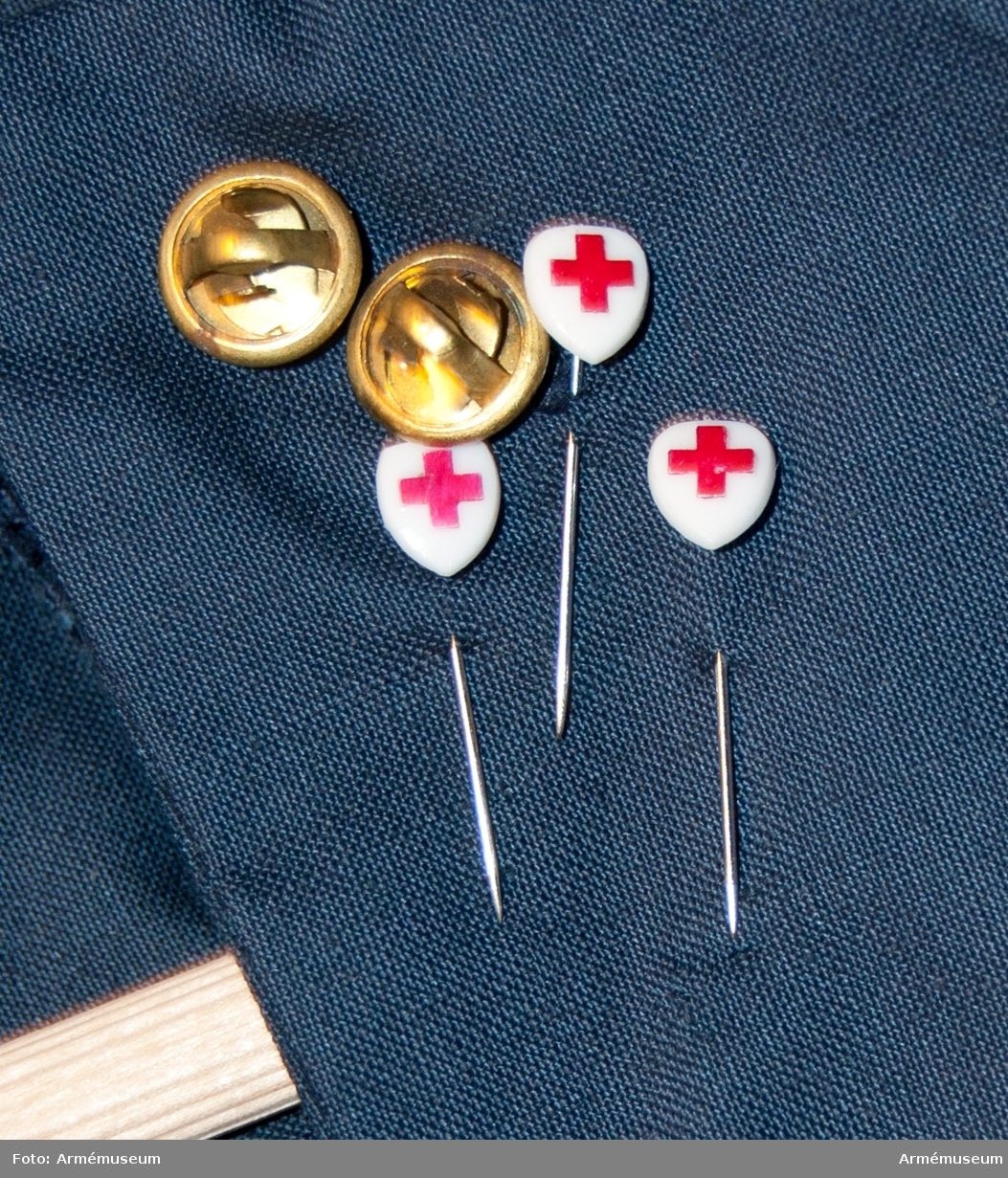 Rockklänning av blått tyg med Svenska Röda korsets tygmärke på överärmen.
Etikett i nacken med text: "Erling Richard 44".
Med samhörande skärp och tre nålar med röda korsetsymbol.