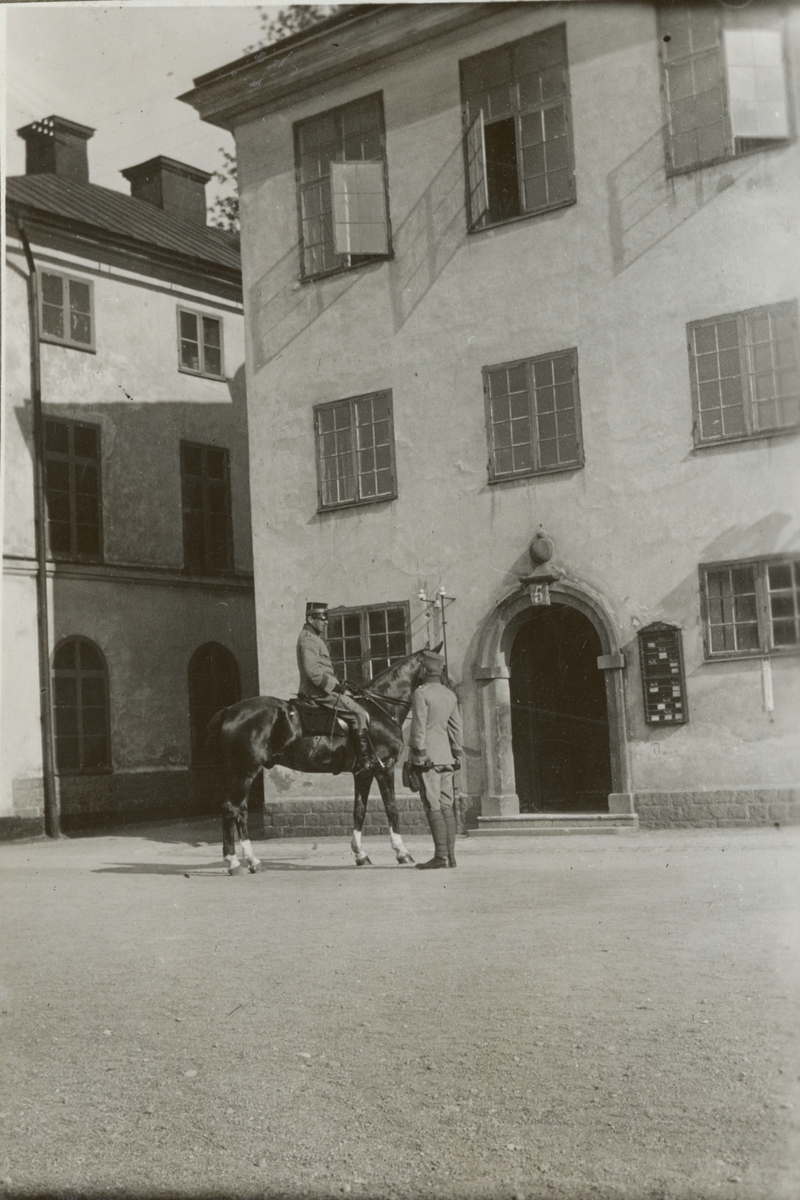 En officerare på häst möter en soldat utanför Militärhögskolan Karlberg.