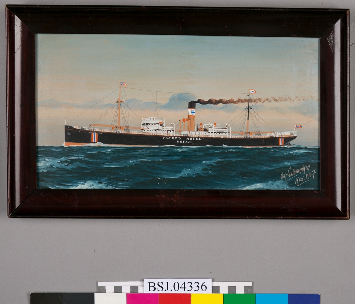 Skipsportrett av DS ALFRED NOBEL under fart i åpen sjø med nasjonalitetsmerke malt på skutesiden samt norsk flagg i akter.