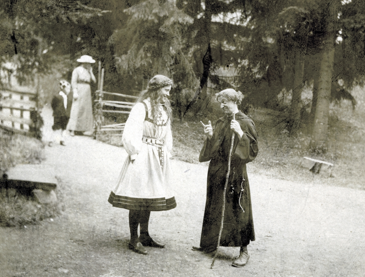 St. Hansfest, Norsk Folkemuseum 1916. Fra teaterforestillingen "Bruderanet". To av skuespillerne med publikum i bakgrunnen.