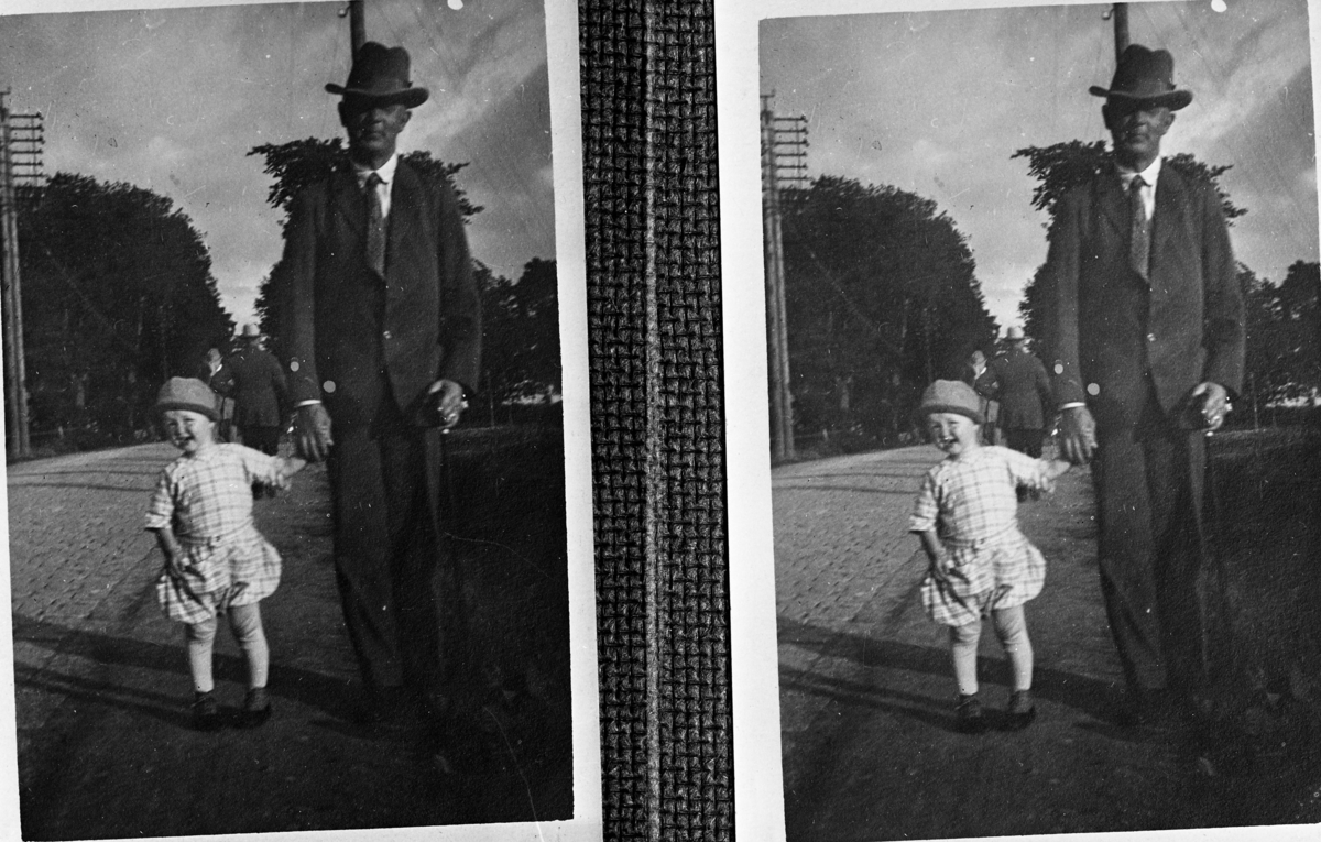 Reprofotografi av man med liten pojke i handen, på promenad.