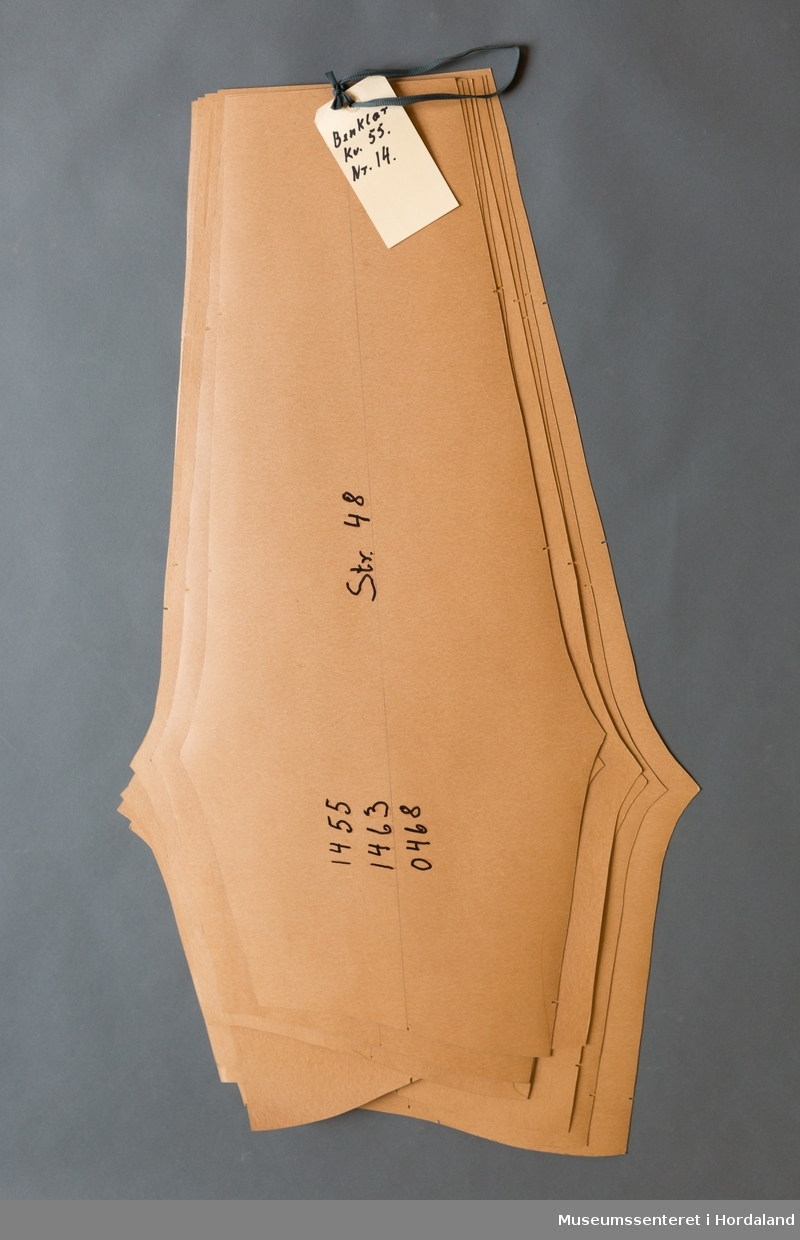 Mønsterskantar i papp, brukt til å skjere ut ulike delar av plagg i klesproduksjon. Desse er til benklær i kvalitet 55, nr. 14. Str. 48-60.