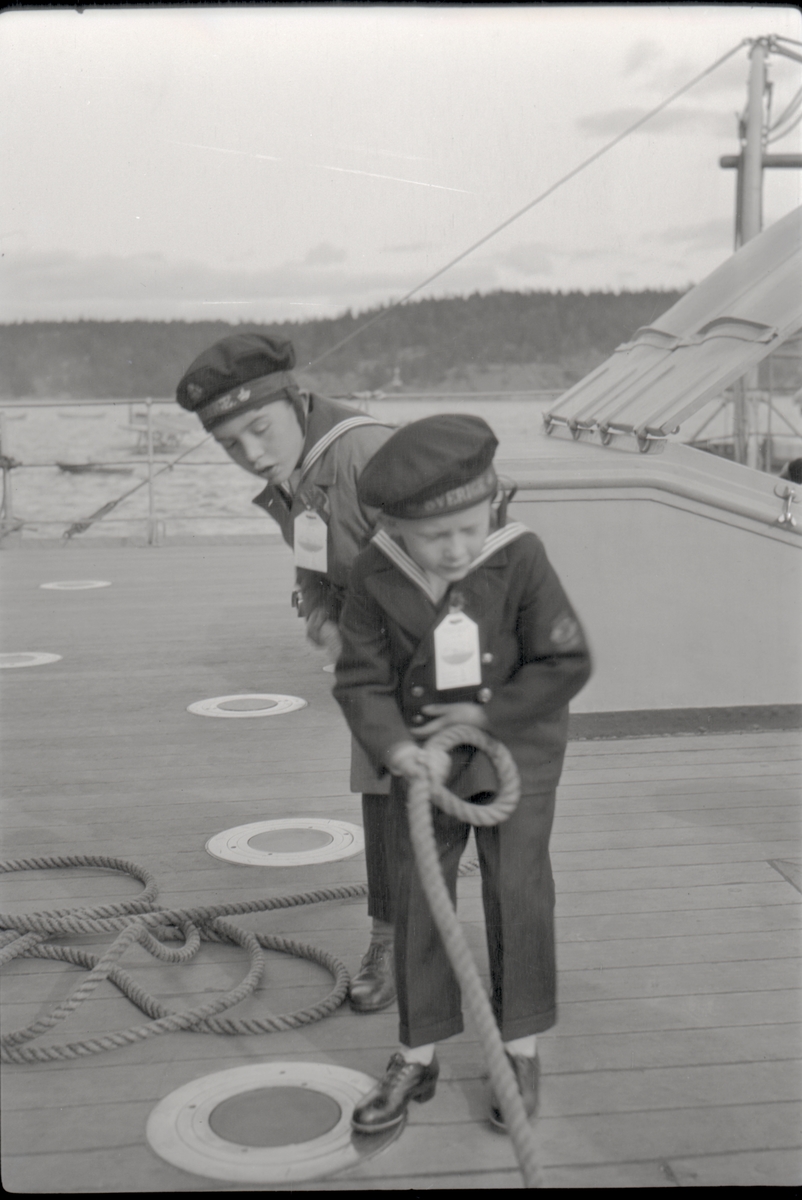 Barn drar i tross ombord på pansarskeppet SVERIGE under Örlogsflottans Ungdomsdag i Saltsjöbaden (Baggensfjärden) 8 september 1929.