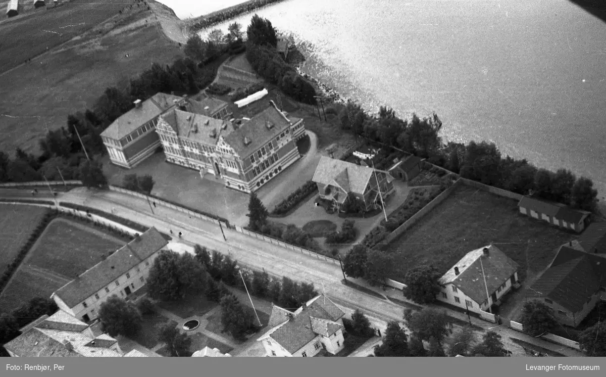 Flyfoto av Levanger, tatt av tenåringen Per Renbjør med sin fars Leica. Den gamle lærerskolen og rektorboligen mot sundet.