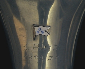 Pokal med lock som krönes av en fisk. 1:a pris 18/9 1938 i Göteborgs segelsällskap.