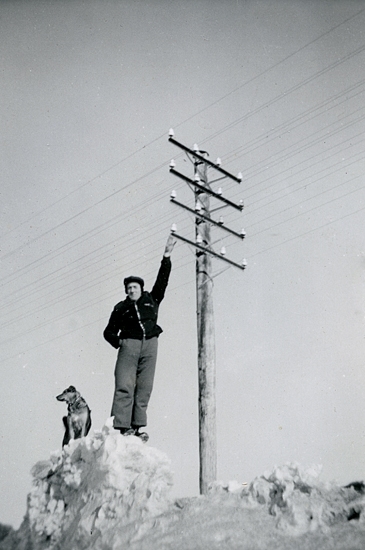 Lars Eriksson och hunden Tussie på en snövall utanför Heljesgården 1940-talet.