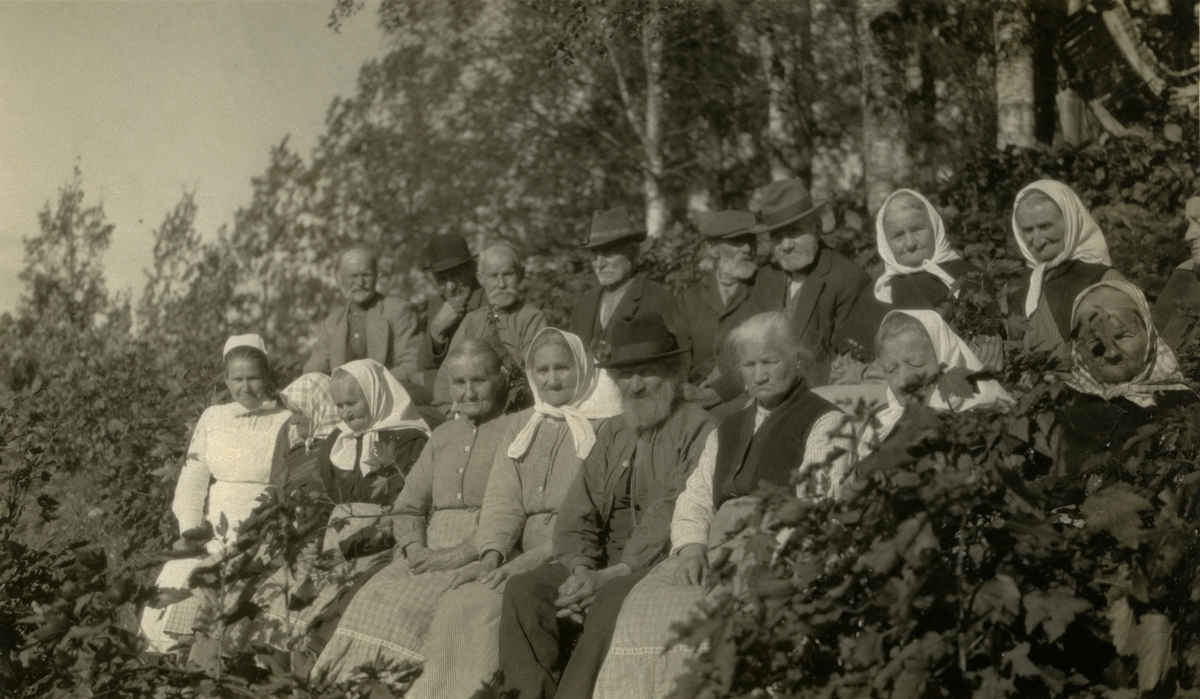 En gruppe eldre mennesker på Trysil Aldershjem, Innbygda (sitter ute, sommer). Sykepleierske lengst til venstre. Nr. 4 fra v. Karen Galaasen, Martins (?) (6/8 1868)