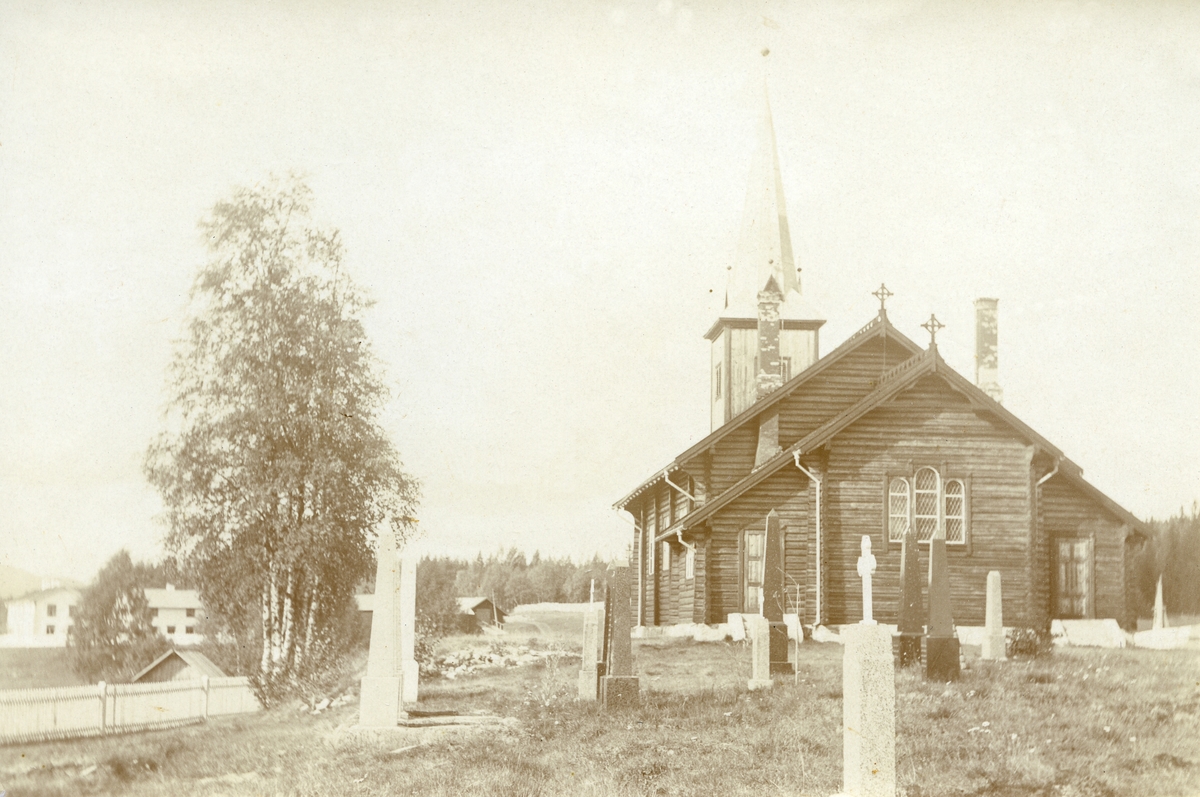 Pladsen kirke fra sør. Kirkegården (gravplassen) i forgrunnen. Gard; Grønneset (Gnr. 3, bnr. 1) i bakgrunnen til venstre