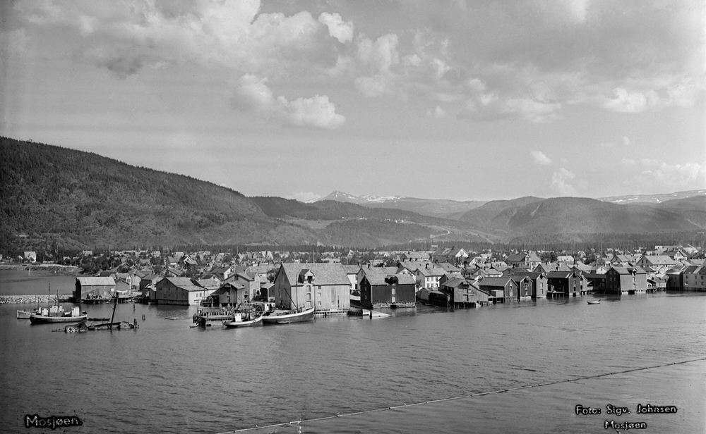 Postkortmotiv tatt fra Gretehaugen like før Marsøra.
Oversikt over nedre del av Sjøgata. Jürgensenkaia med flere båter, fyllinga mot bordveneset er kommet. Tømmerlense i elva.