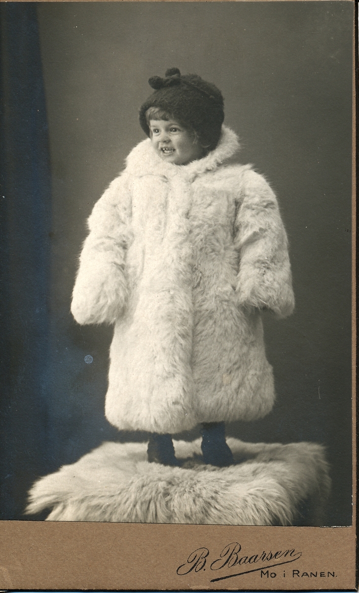 Liten jente i pels og strikket lue. B. Baarsen Bostrøm datter, Gudfrid Bostrøm