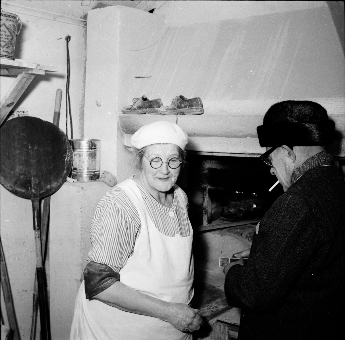 Bakerskan Arvida Johansson bakar Ovanåkersbröd.
Edsbyn december 1956.