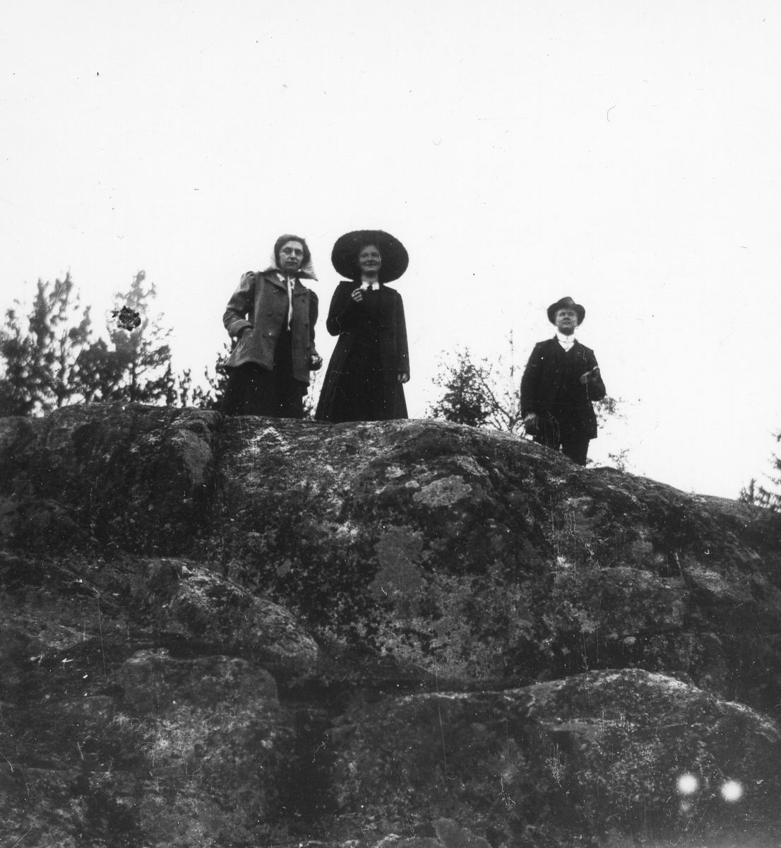 En man och två kvinnor på bergstopp.