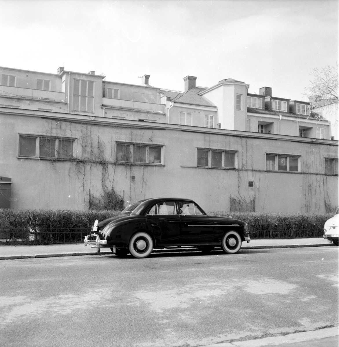 BIl och byggnad i bakgrunden, 1958.