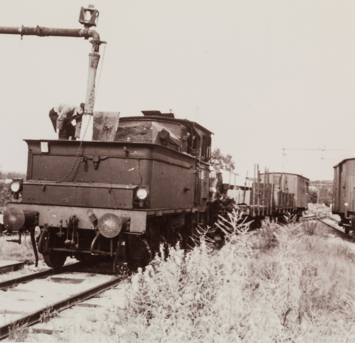 Vannfylling på damplokomotiv type 21 på Skotterud stasjon. Toget trafikkerer Vestmarkalinjen, Skotterud-Vestmarka.