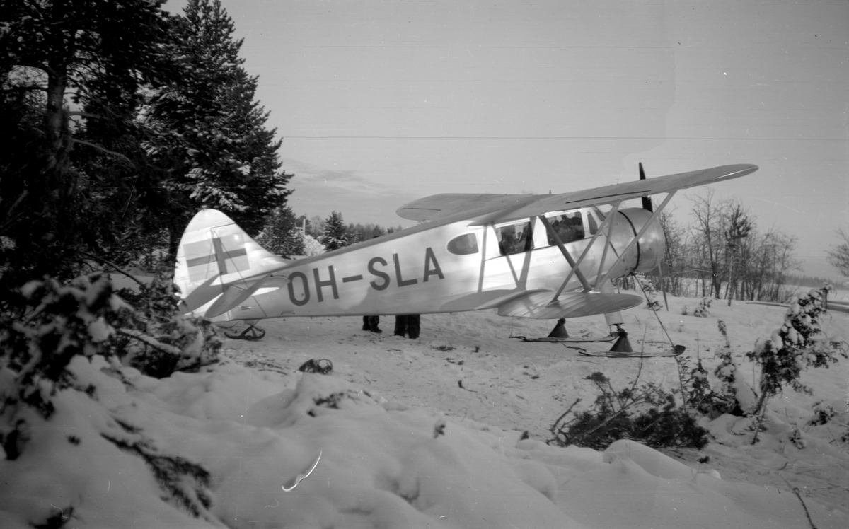 Flygplan Waco ZQC-6 registreringsnummer OH-SLA står på marken vid F 19, Svenska frivilligkåren i Finland. Vy snett bakifrån.
