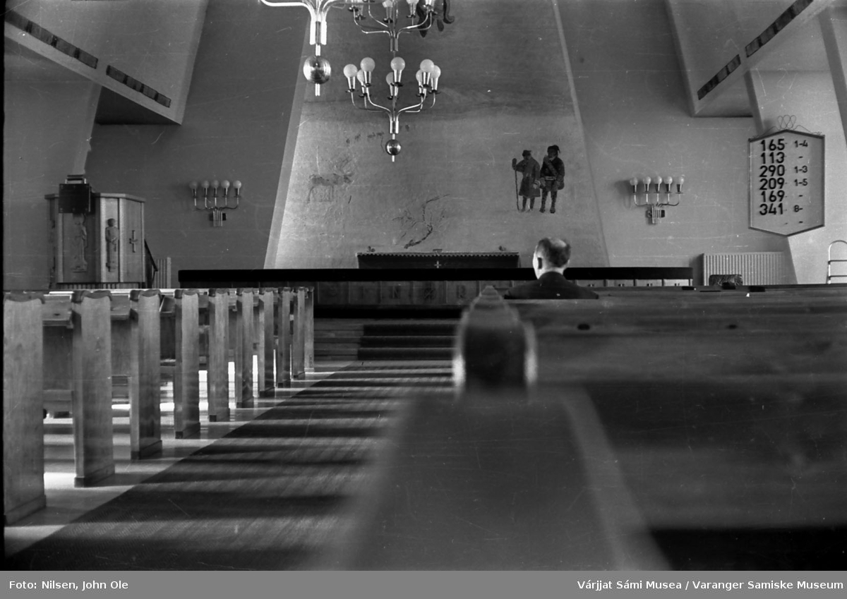 Kirkerommet i Hetta kirke med altertavlen sentralt i bildet. Antageligvis Henrik Ravna som sitter fremme i kirka. Juli 1967.
