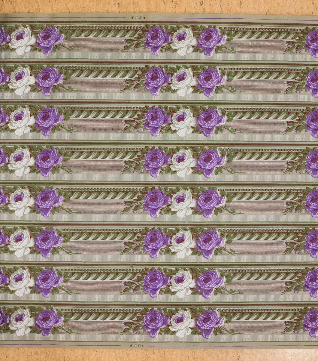 Tapetrulle med åtta rader med tapetbård. Dekor med blommönster i lila.