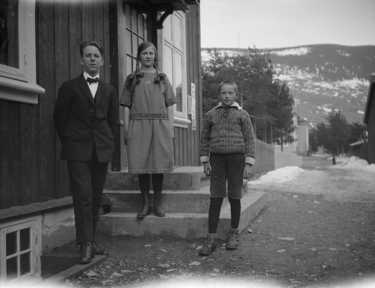 Fra venstre står Ivar Kluften med en jente med lange fletter og en gutt med knebukser på trappen ved Furuly, Vålebru.