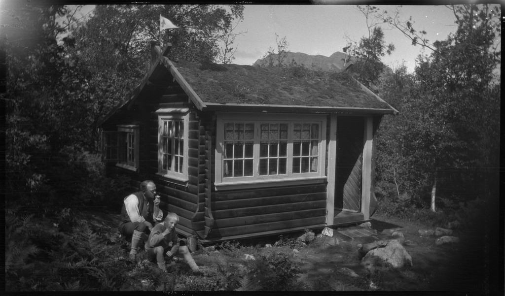 Finn Torgrimsen og en eldre Torgrimsen (muligens far eller bestefar) sitter utenfor hytta deres på Vikeså i Bjerkreim.