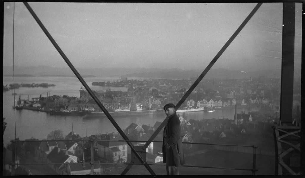 Per Årseth (bilde 1)  og en annen mann (bilde 2) ser ut over Stavanger fra toppen av en gassverkbeholder.