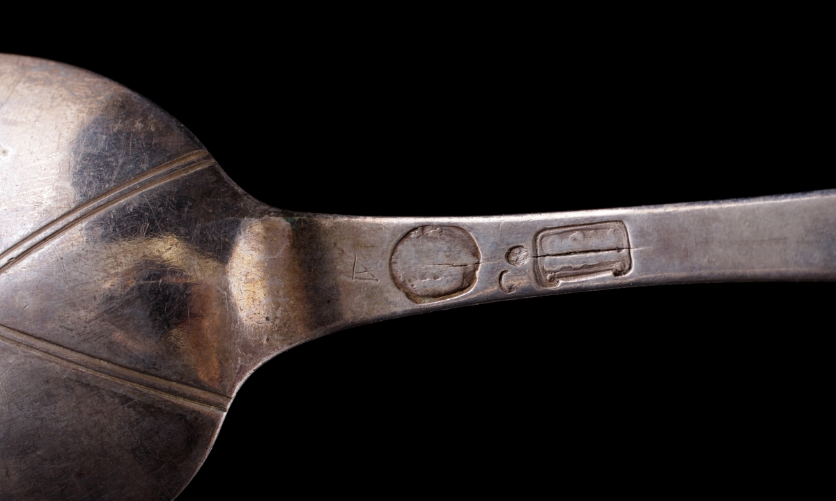 Matsked i silver.
Slät fiolmodell. På baksidan av skaftet ägarinitialer och årtal: "P.M.L., 1758" under adlig krona. Stämplar (mycket otydliga) på skaftets baksida.
