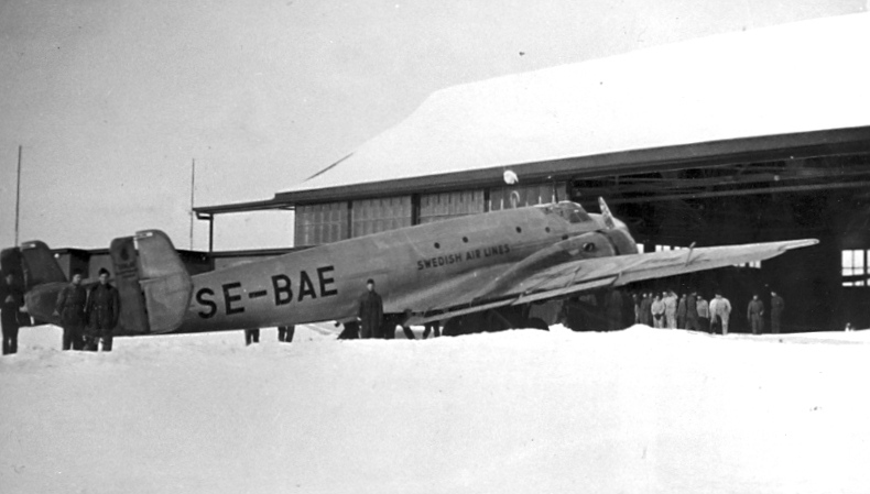 F6 Karlsborg 1940. JU86Z7 SE-BAE "Svalan" gästar flottiljen. Levererades i mars 1938 och var enkom för ABA:s räkning ombyggt som postflygplan. Användes på nattpostlinjen Stockholm-Malmö-Hannover fram till krigsutbrottet, då nattpostflygningarna måste inställas. I oktober 1940 inköptes planet av flygvapnet och blev transportflygplan under beteckningen Tp9. Här utanför 3. Divisionens hangar. Albumet är en del av en donation från Karl-Axel Hansson, Karlsborg. Förteckning över hela donationen finns i albumet samt som Word-dokument.