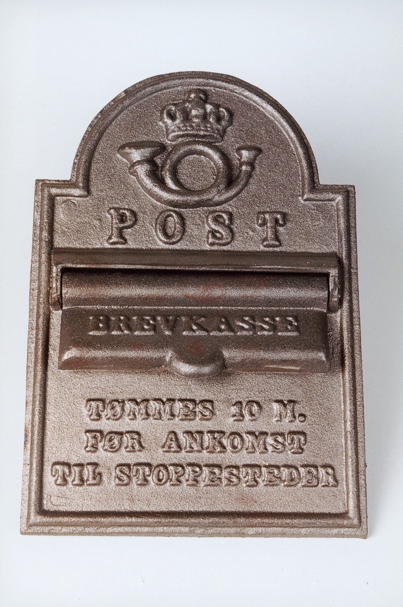 Postinnkast i metall for postekspedisjon på tog/ båt.  Påskrift om at postinnkastet tømmes 10 minutter før ankomst stoppested.