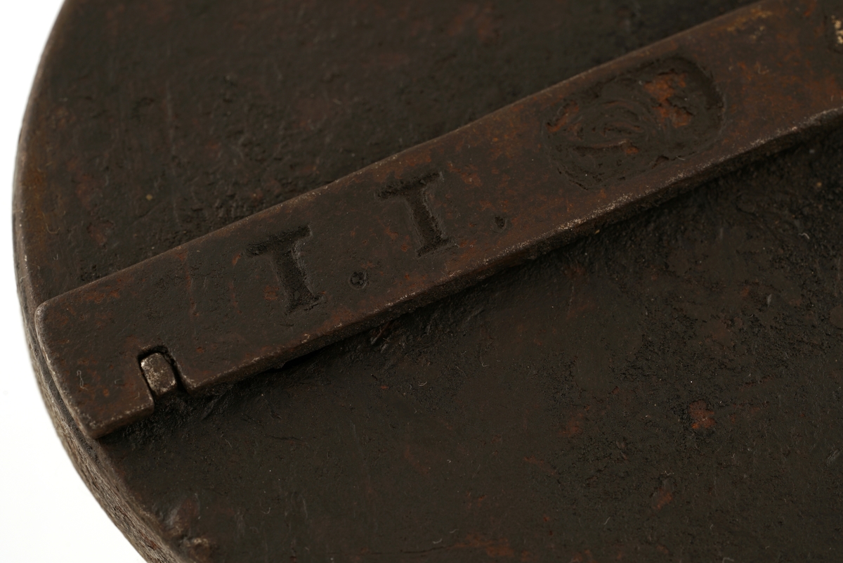 Hengelås av jern, oval med svingbart lokk over nøkkelhull.
Nøkkel av jern med skjegg formet somkroker. Gjennombrudt.