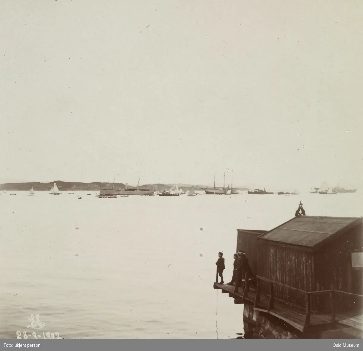 utsikt, fjord, båter, skip, "Heimdal" med "Fram" på slep, badehus, mennesker