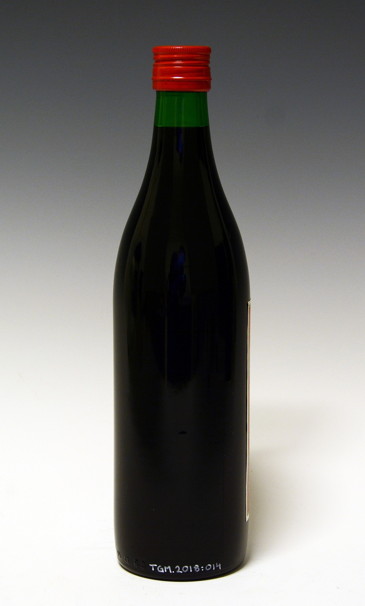 Grønn flaske med rød metallkork og rød og hvit etikett, med innhold.