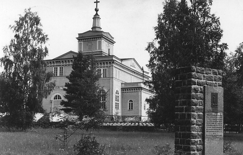 Rautalampi kyrka med utvandrarmonumentet till minne av utvandrare till Sverige och USA.