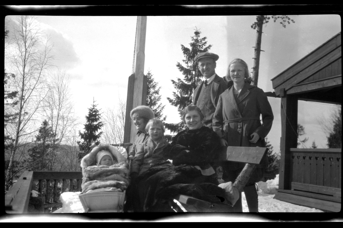 Rolf Sundt Jr. i vuggen, barnepiken, Julius, Hilda og Rolf Sundt Sr. samt Julie Cecilie (Essemor) Sundt på terrassen til Villa Knyggen i Voksenlia, Oslo. Fotografert 1922.
