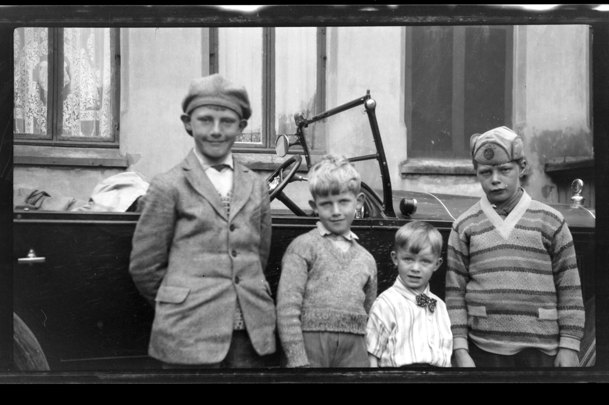 Julius Sundt, Rolf Sundt jr, Arne Moestue og Einar Aubert Hansen står foran en bil, Drammen. Fotografert 1928.