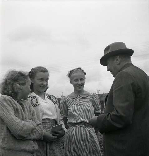 Några flickor och en man står i en grupp och pratar. Unga Odlare 1948 - 1949.