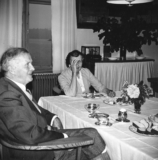 Enligt uppgift: "Hans Pettersson med fru Dagmar på kaffe hos ÅkermoÂ´s. Fotografiet taget i biblioteket, 1960-talet".