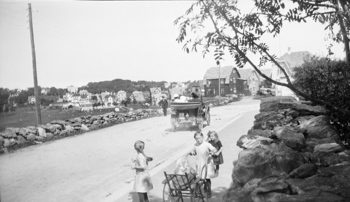 Bil körande på väg, möjligen är det familjen Liljefors som sitter i, barn vid vägen, Stavanger i Norge